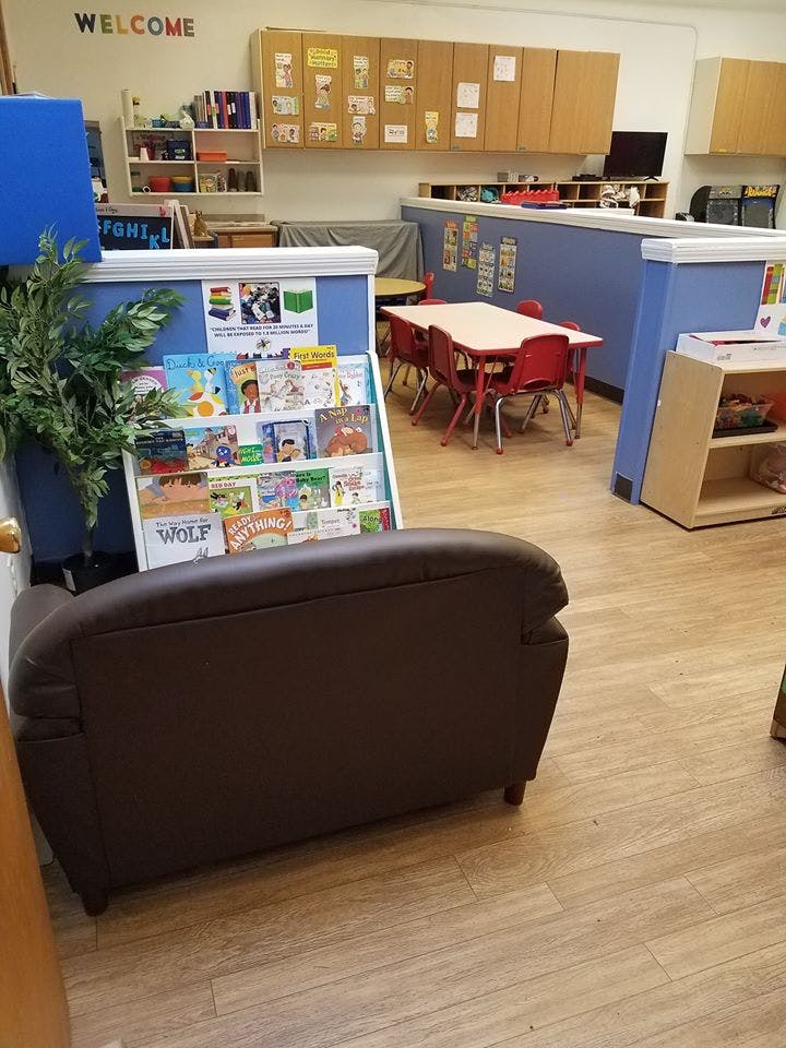 Children's classroom with a book display, small tables, and a couch