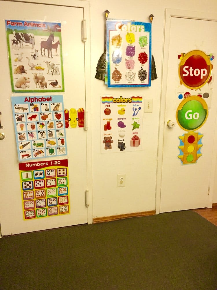 Classroom door with educational posters including farm animals, alphabet, and numbers