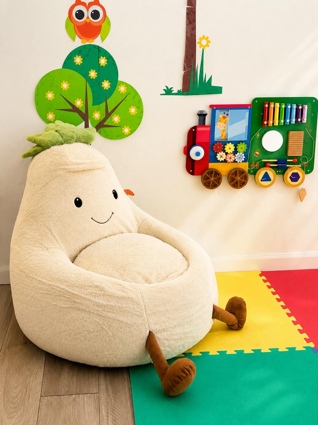 Plush pear chair in a playroom with wall decals and a toy train activity board