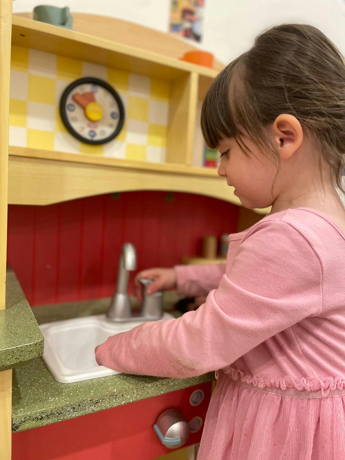 Child playing with a toy kitchen sink
