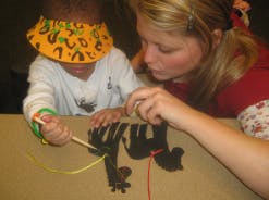 Adult and child lacing a craft