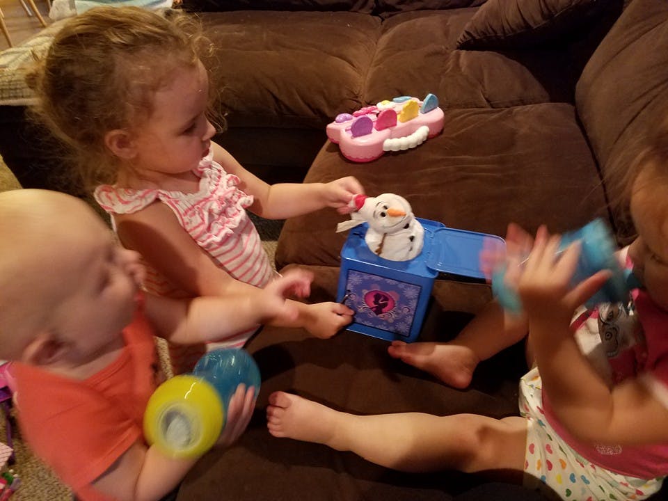 Two children playing with toys on a couch