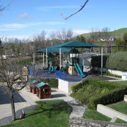 Playground with slides and climbing structures under a canopy
