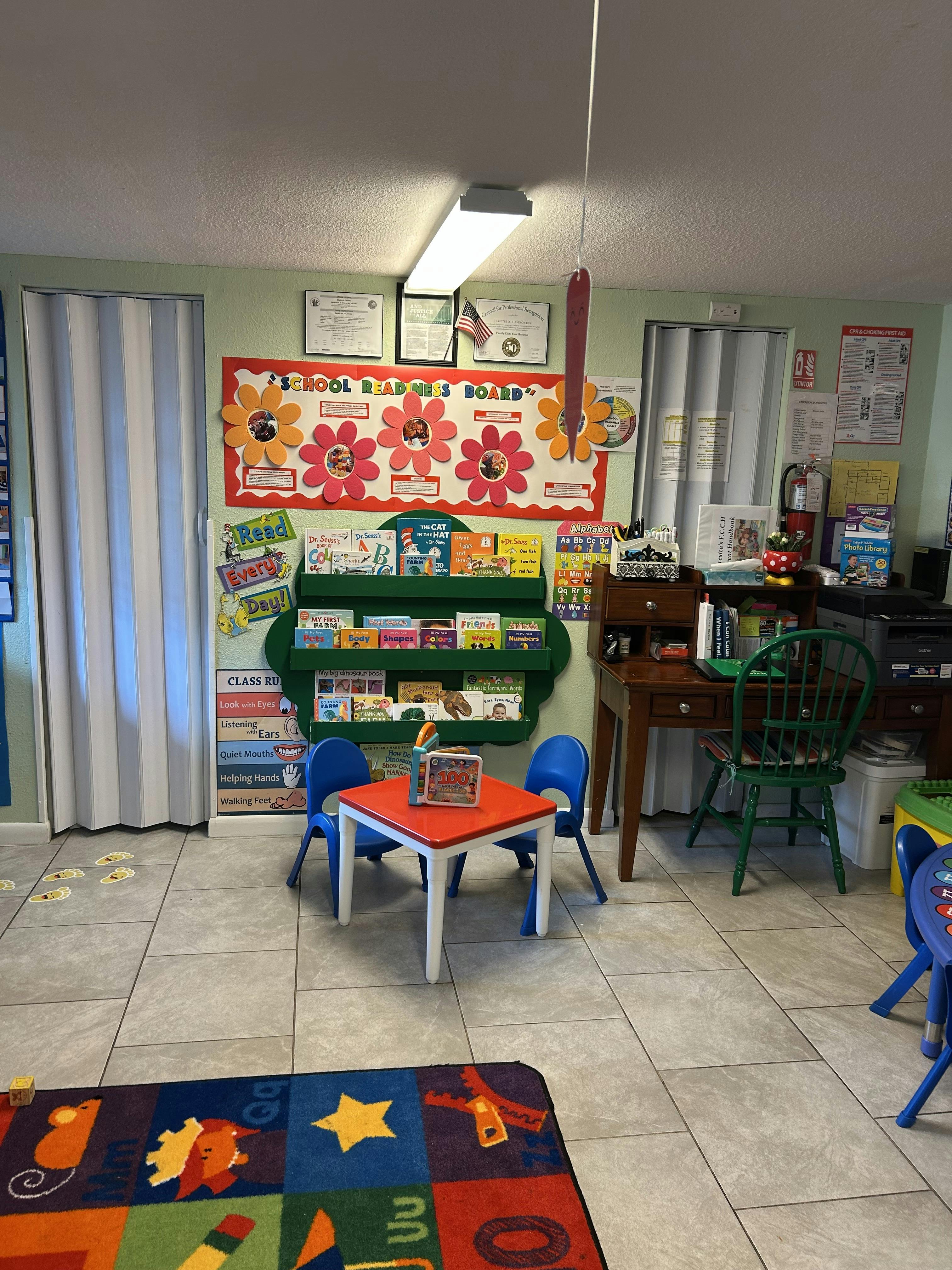 children's classroom with a school readiness board, book display, and small table with chairs