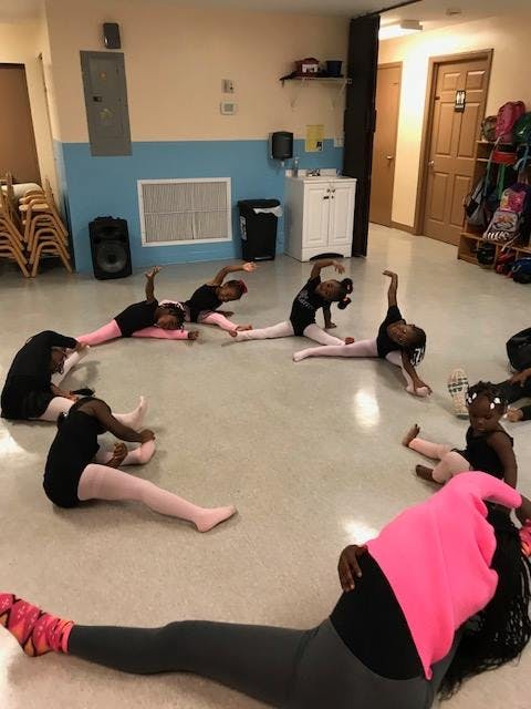 Children stretching on the floor in a dance studio