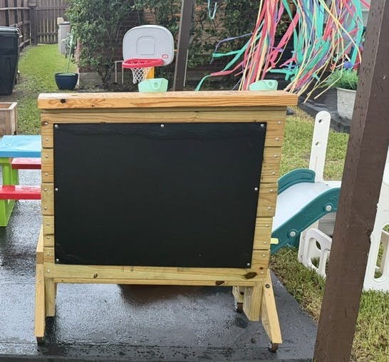 Wooden outdoor chalkboard in a backyard play area