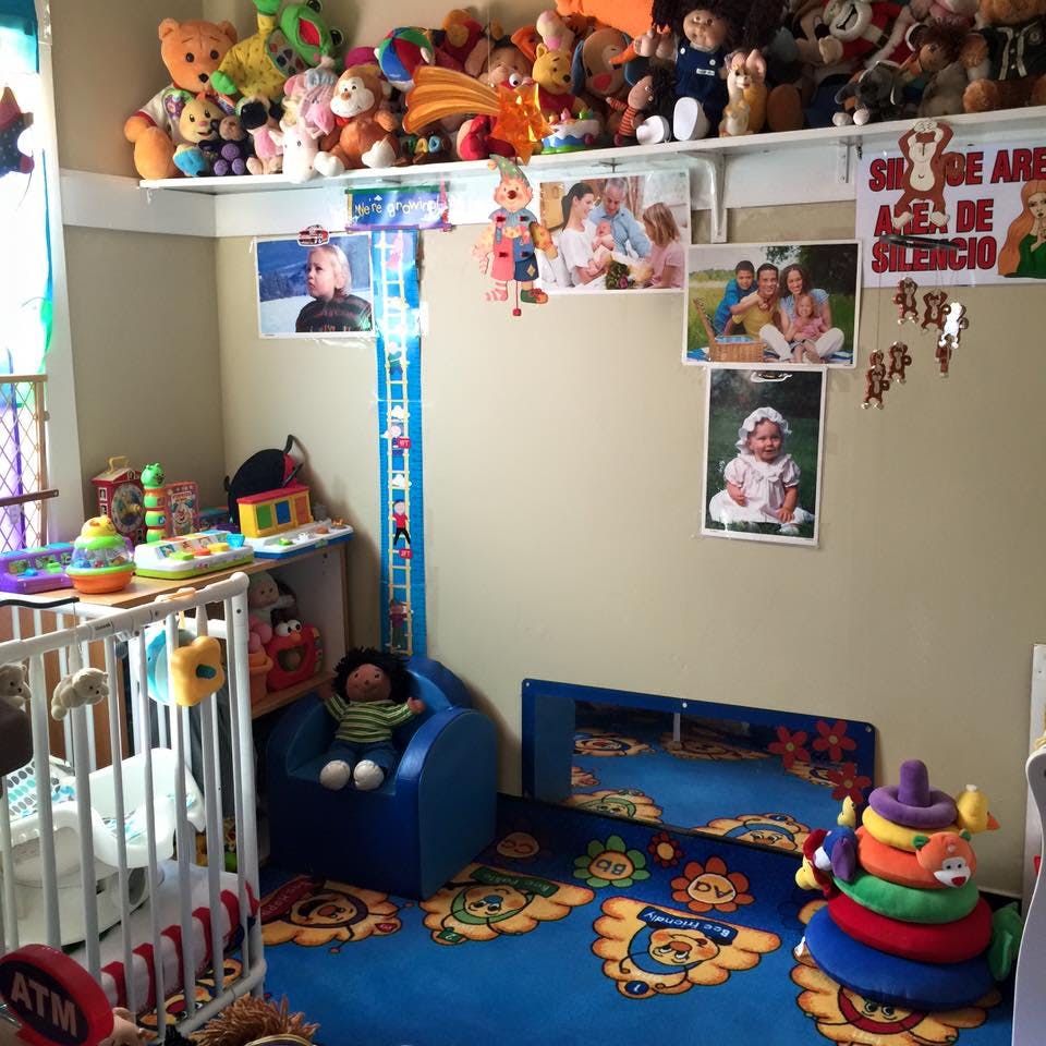 Nursery room with a crib, blue rug, and shelves of stuffed animals