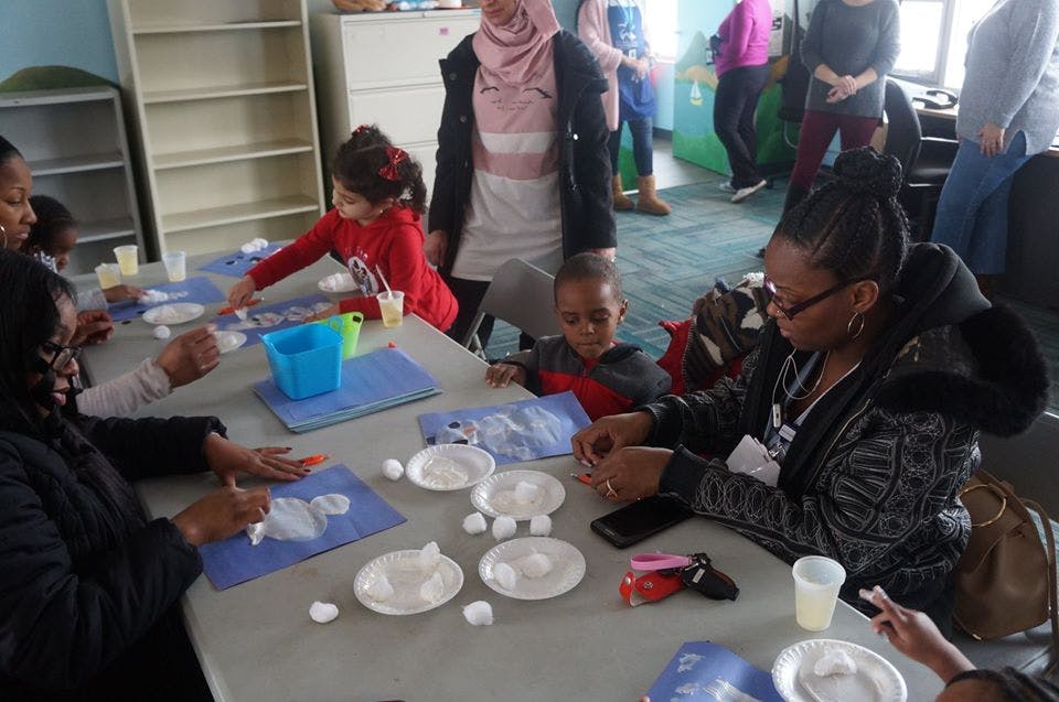 Adults and children doing crafts at a table