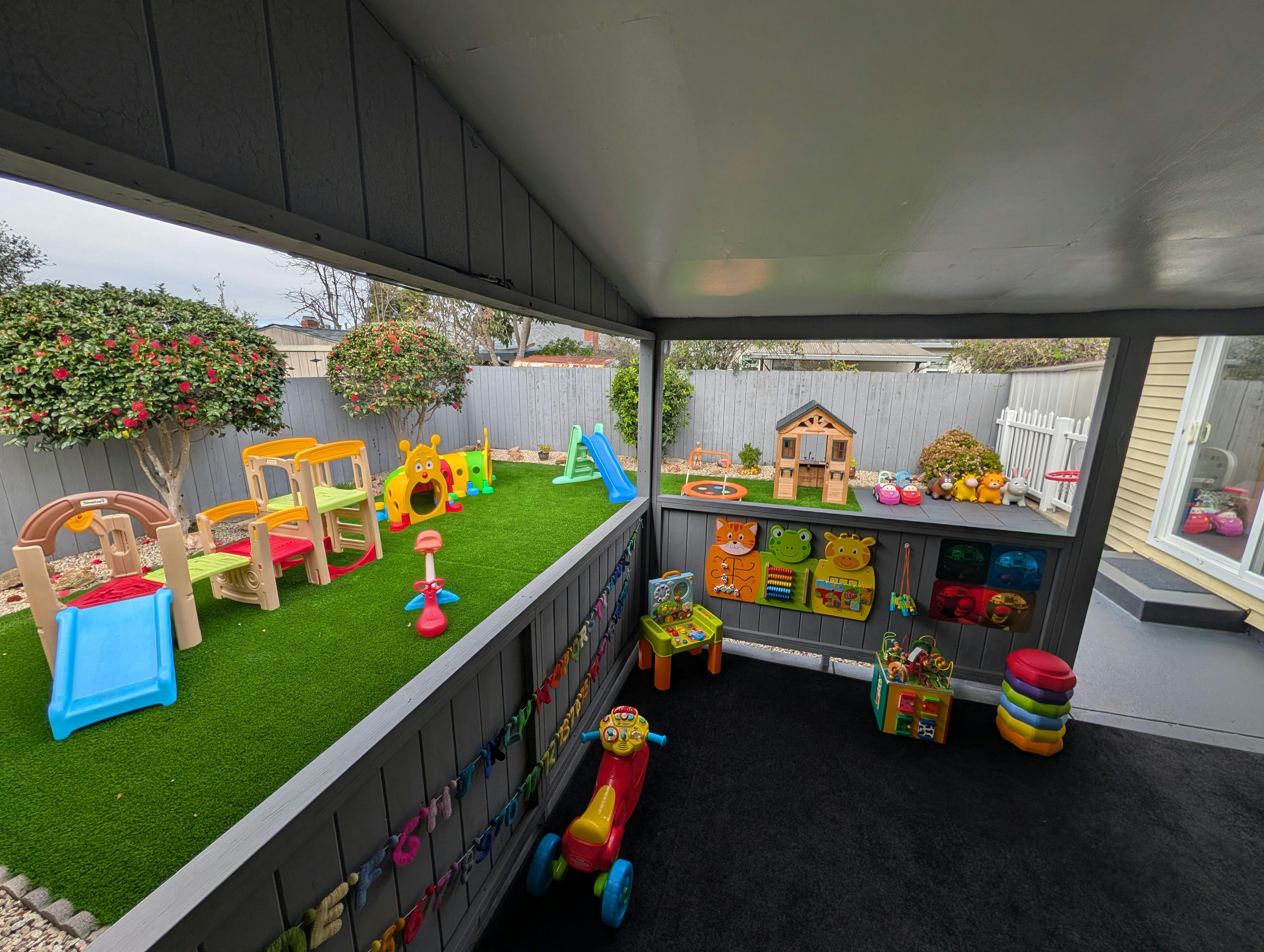 Outdoor children's play area with artificial grass and play equipment