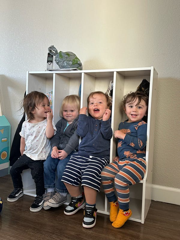 Four children sitting in cubbies