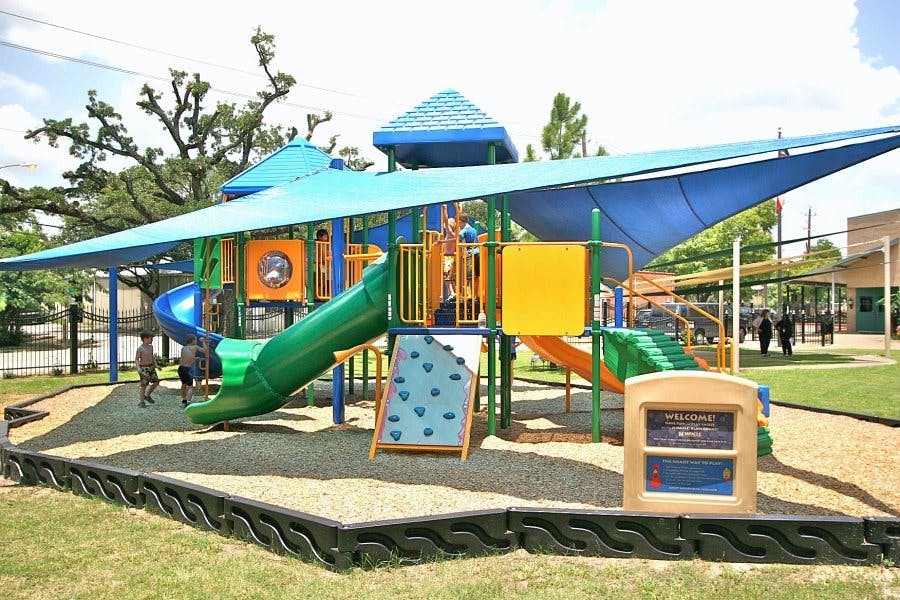 Children playing on a playground with slides and climbing structures