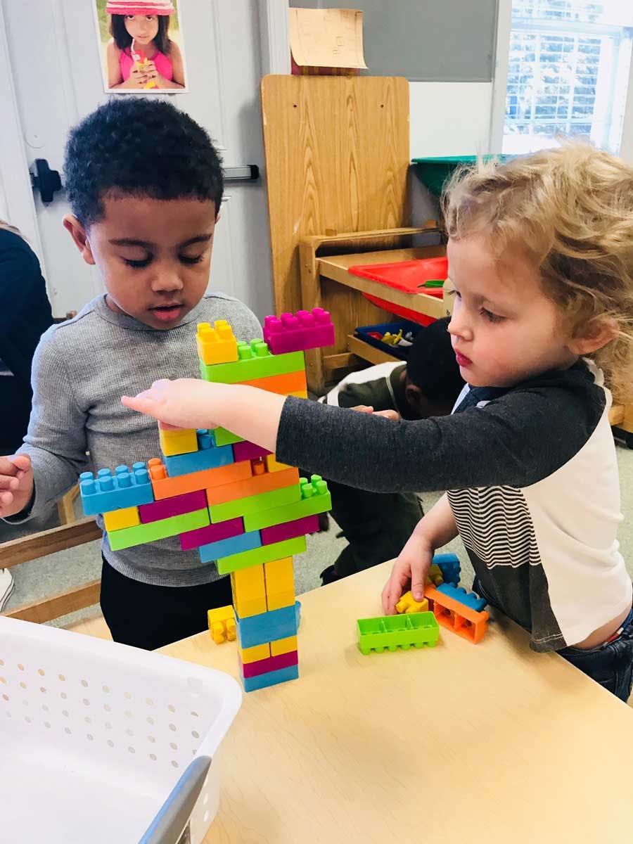 Two children playing with colorful building blocks