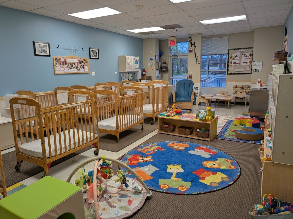 Cribs and play area in a brightly lit daycare classroom