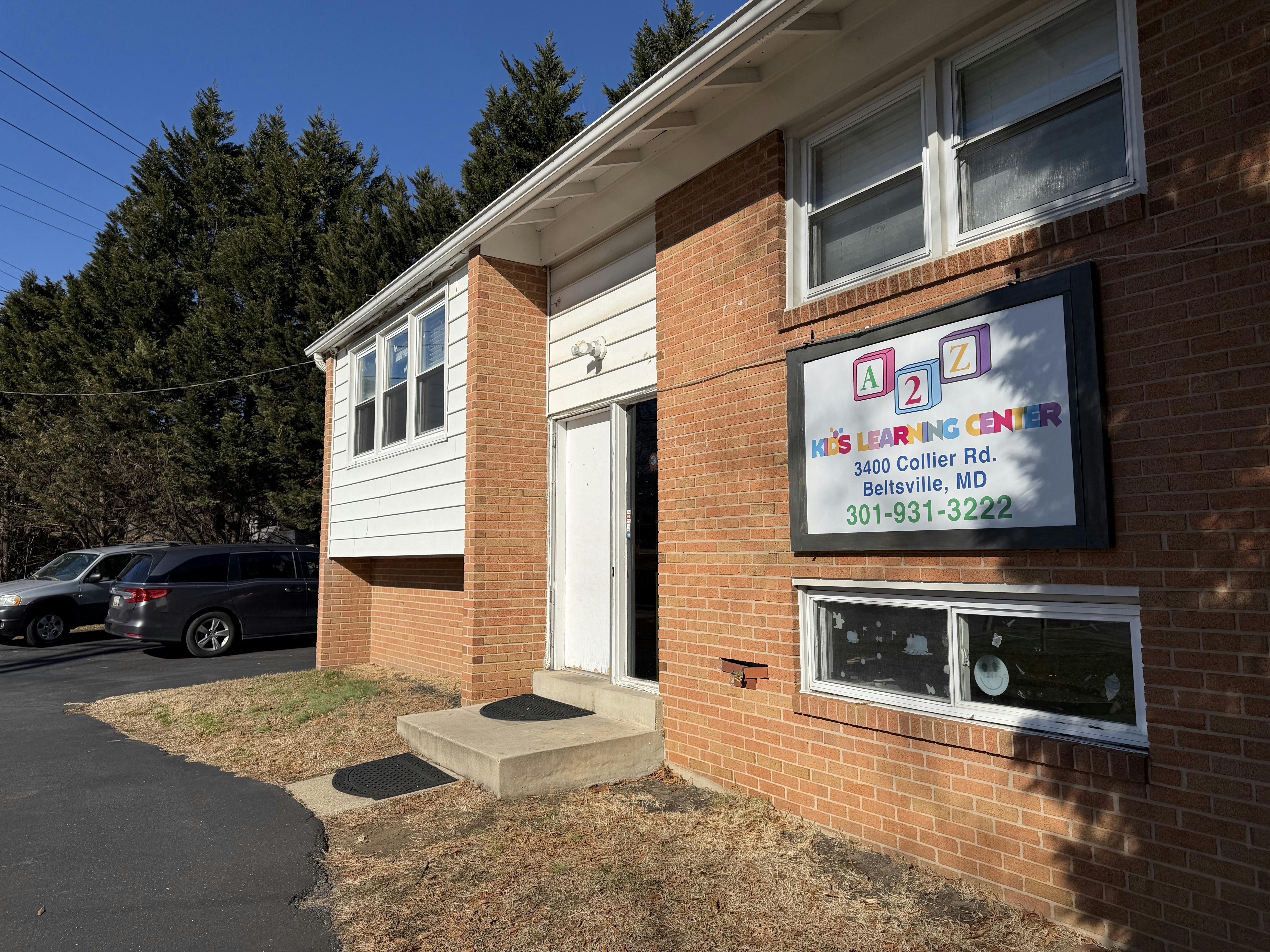 Brick building with a sign for "A 2 Z Kids Learning Center" next to an open door