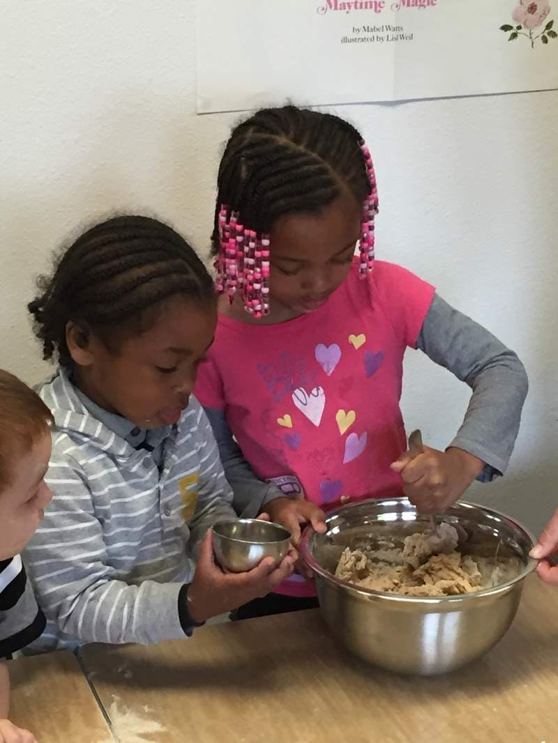 Two children mixing ingredients in a bowl