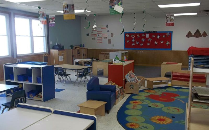 Classroom with small tables, chairs, and play furniture
