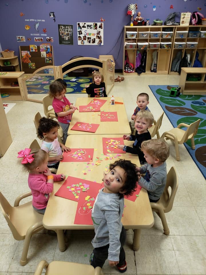 Children doing crafts at tables in a classroom
