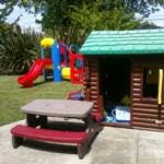 Playhouse and picnic table with a slide in the background