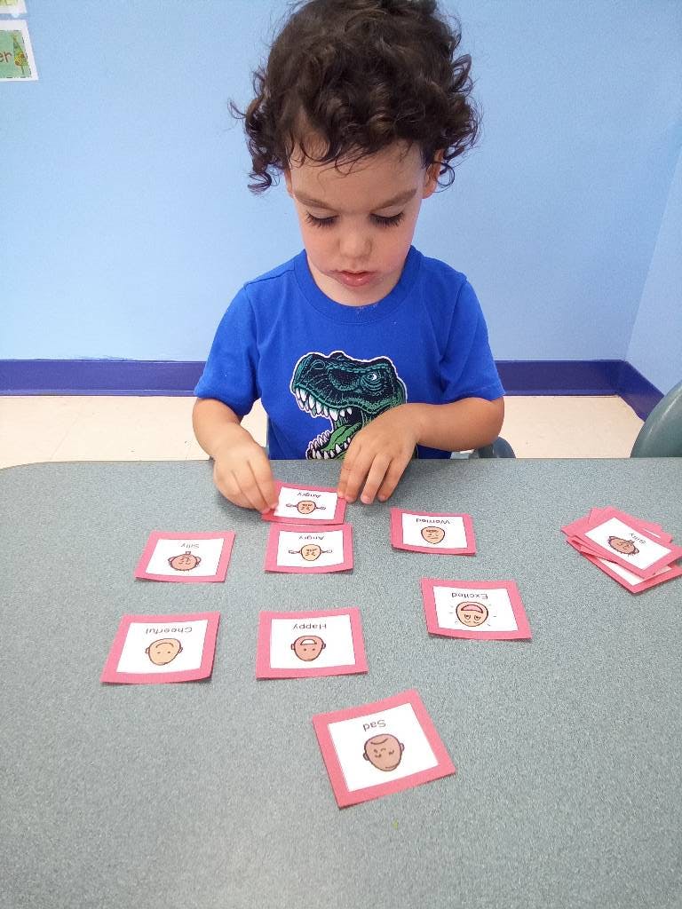 Child playing with flashcards on a table
