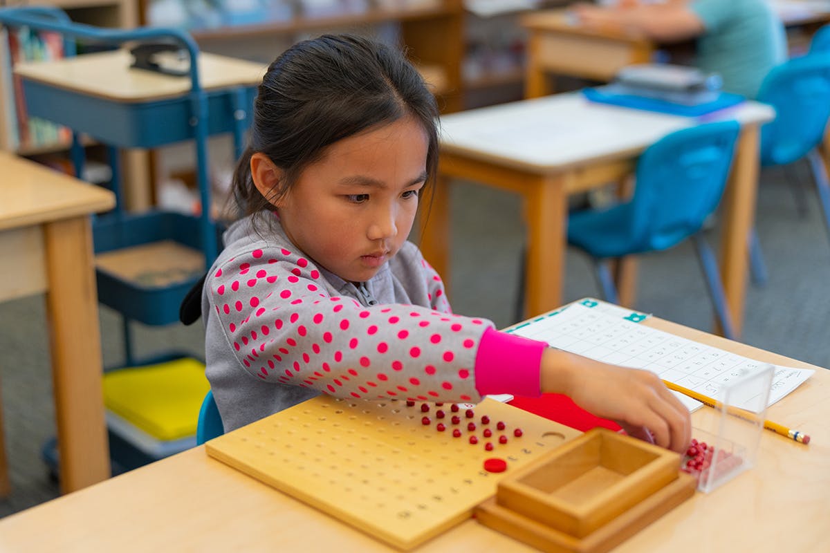 Child working with a math manipulative in a classroom