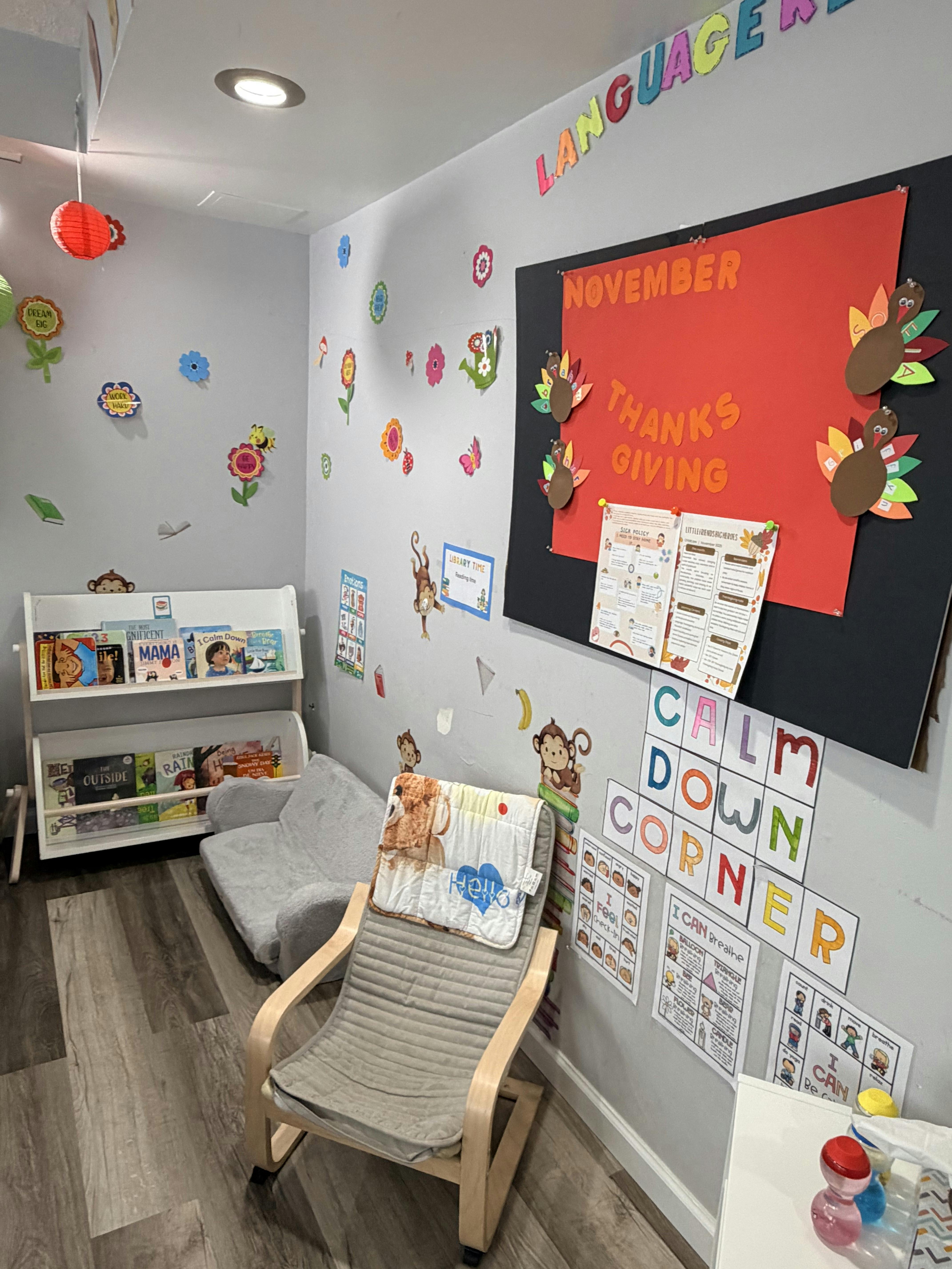 Classroom corner with book display, reading chair, and Thanksgiving-themed bulletin board