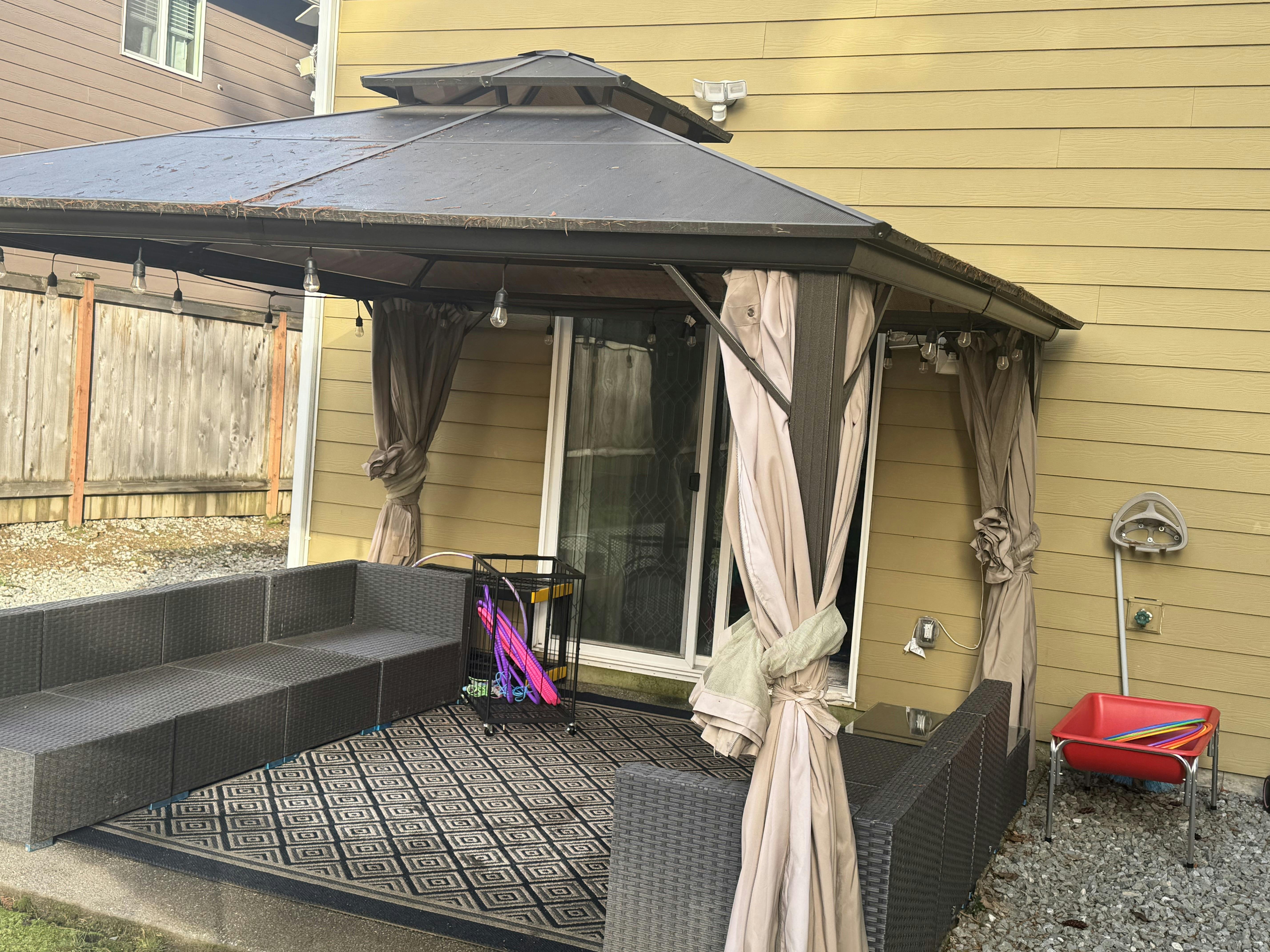 Outdoor patio with a gazebo, seating, and a sliding glass door
