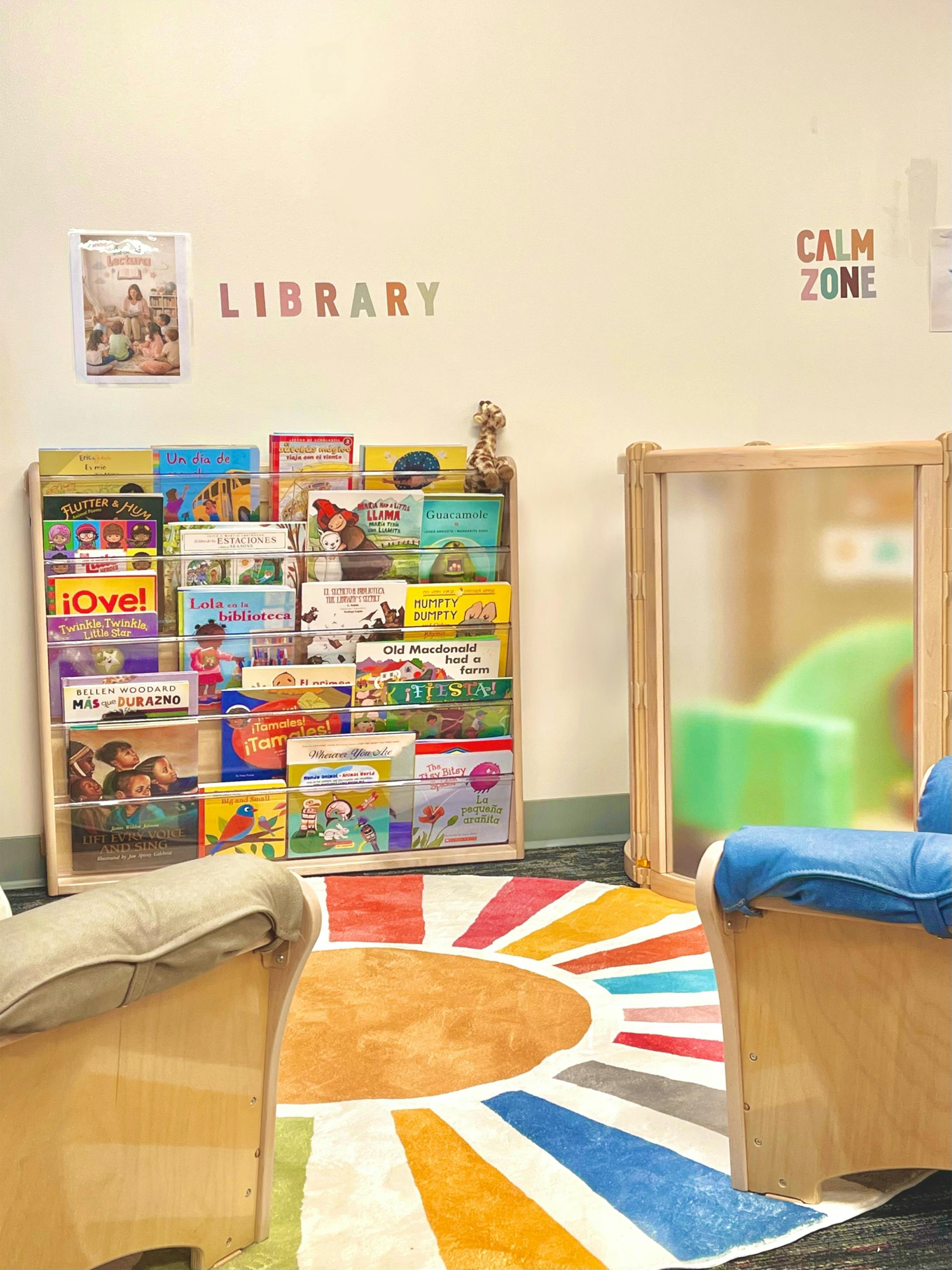 Children's library corner with book display, chairs, and colorful rug