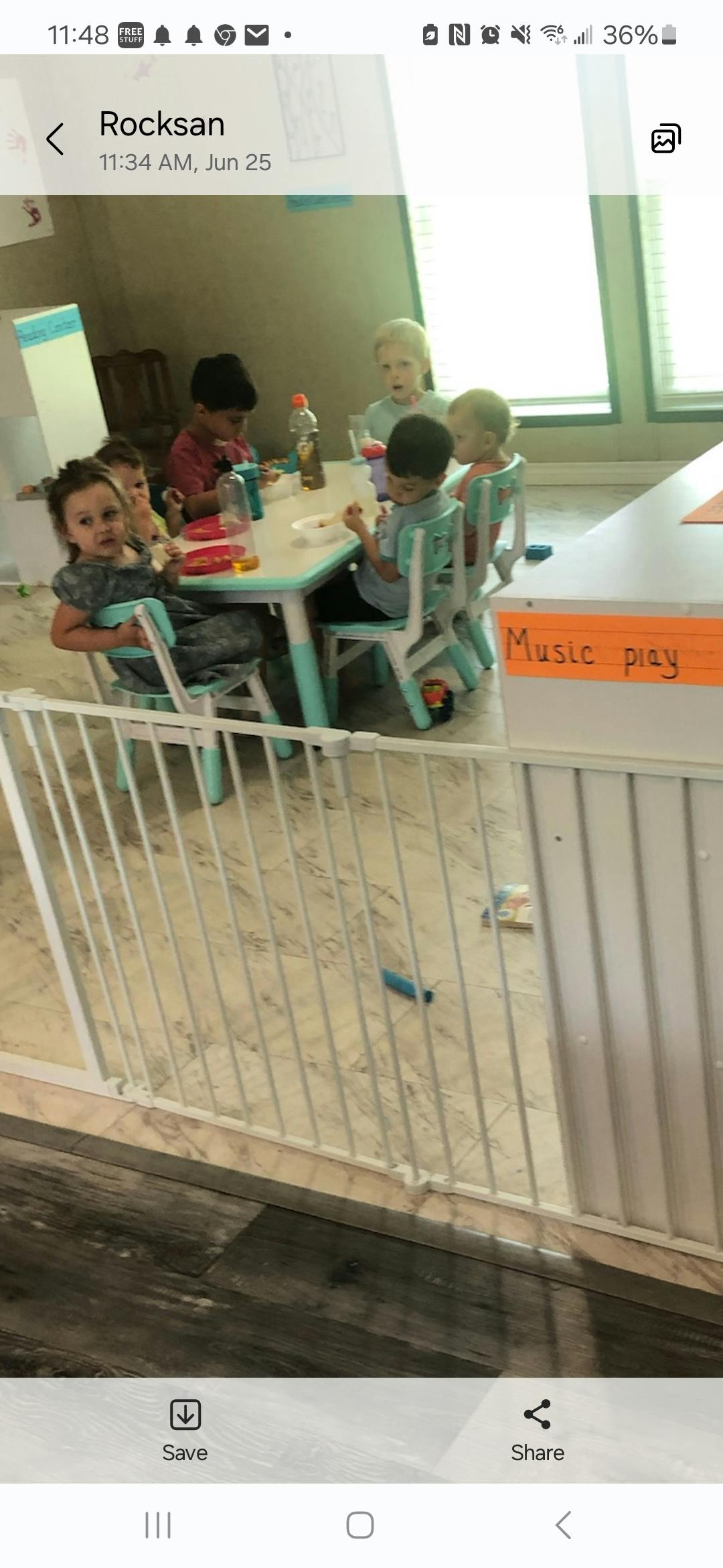 Children sitting at a table with a sign that reads "Music play"