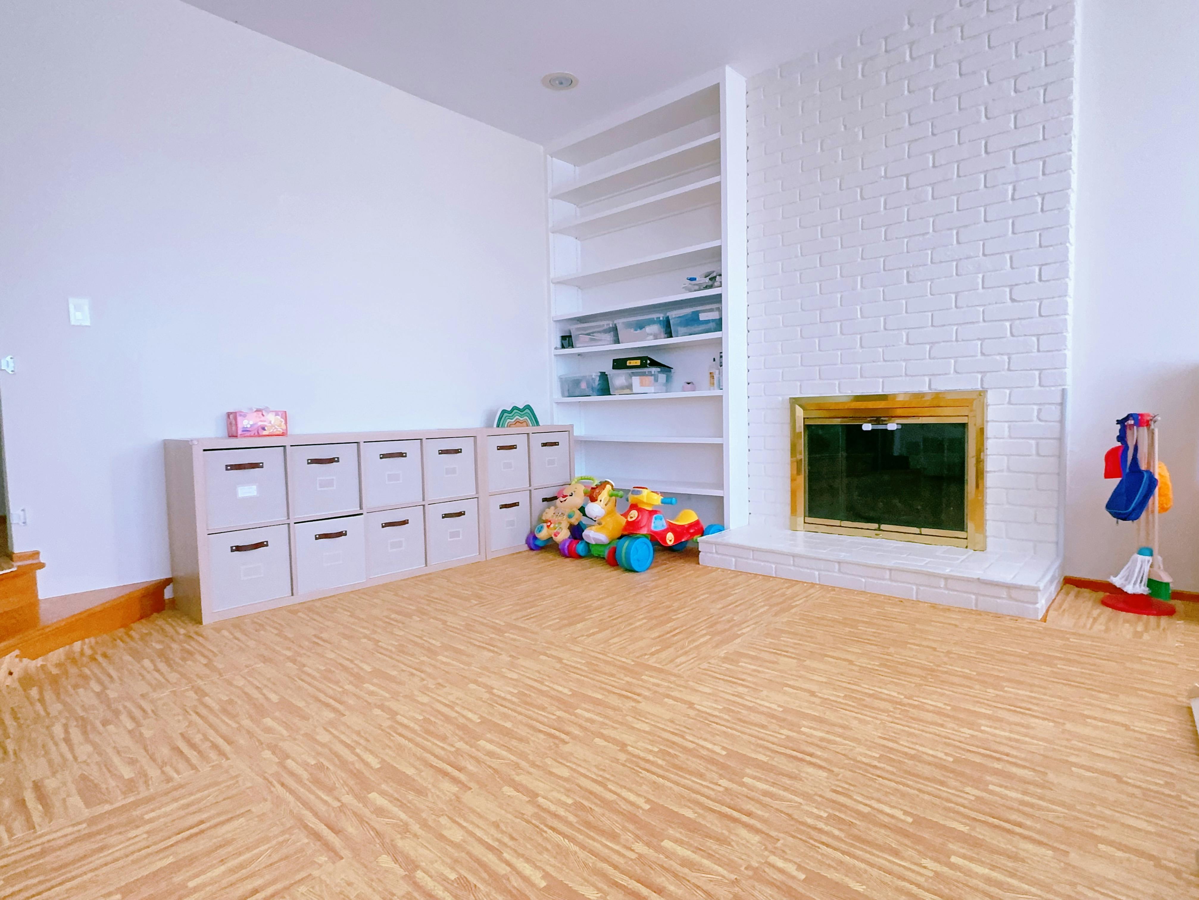 Playroom with storage units, toys, and a fireplace