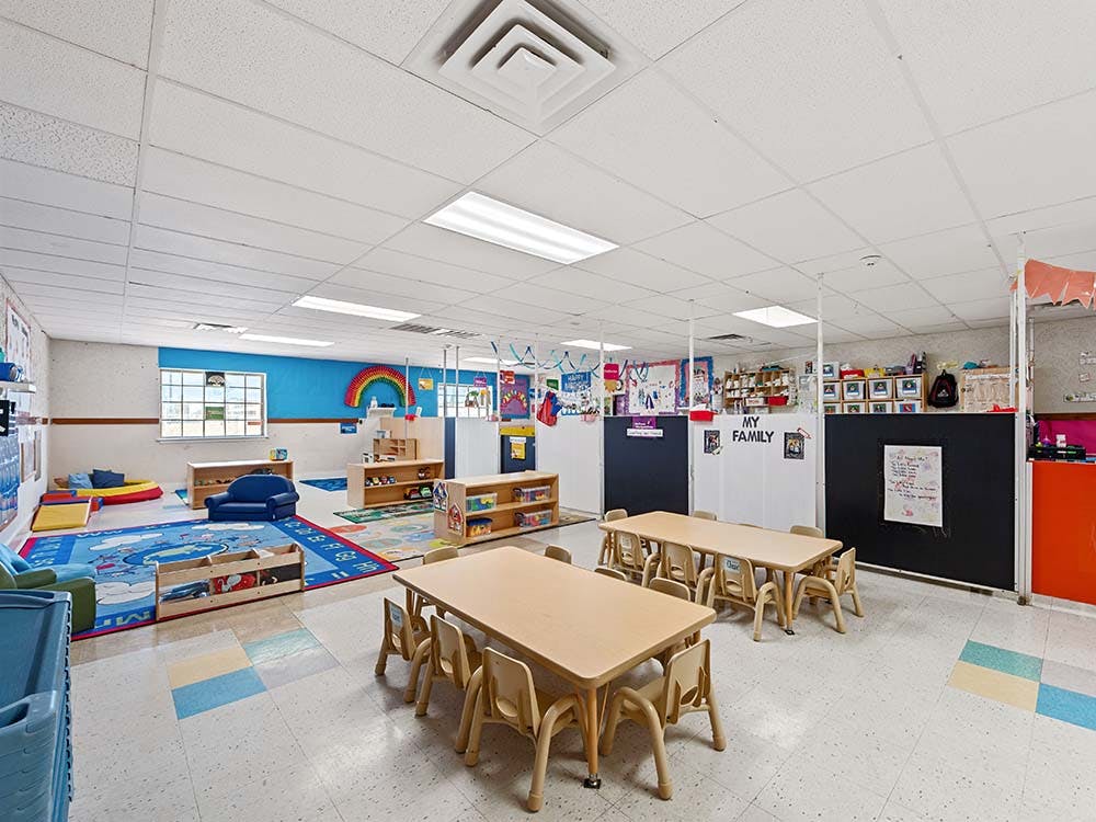 Empty colorful playroom with small tables and chairs for children