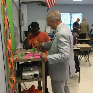 Adult and teen working with craft materials in a classroom