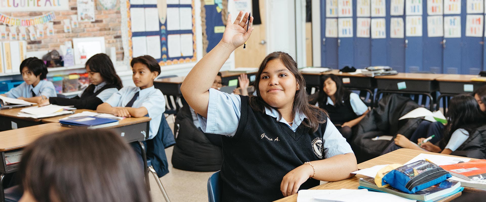 Child raising hand in a classroom