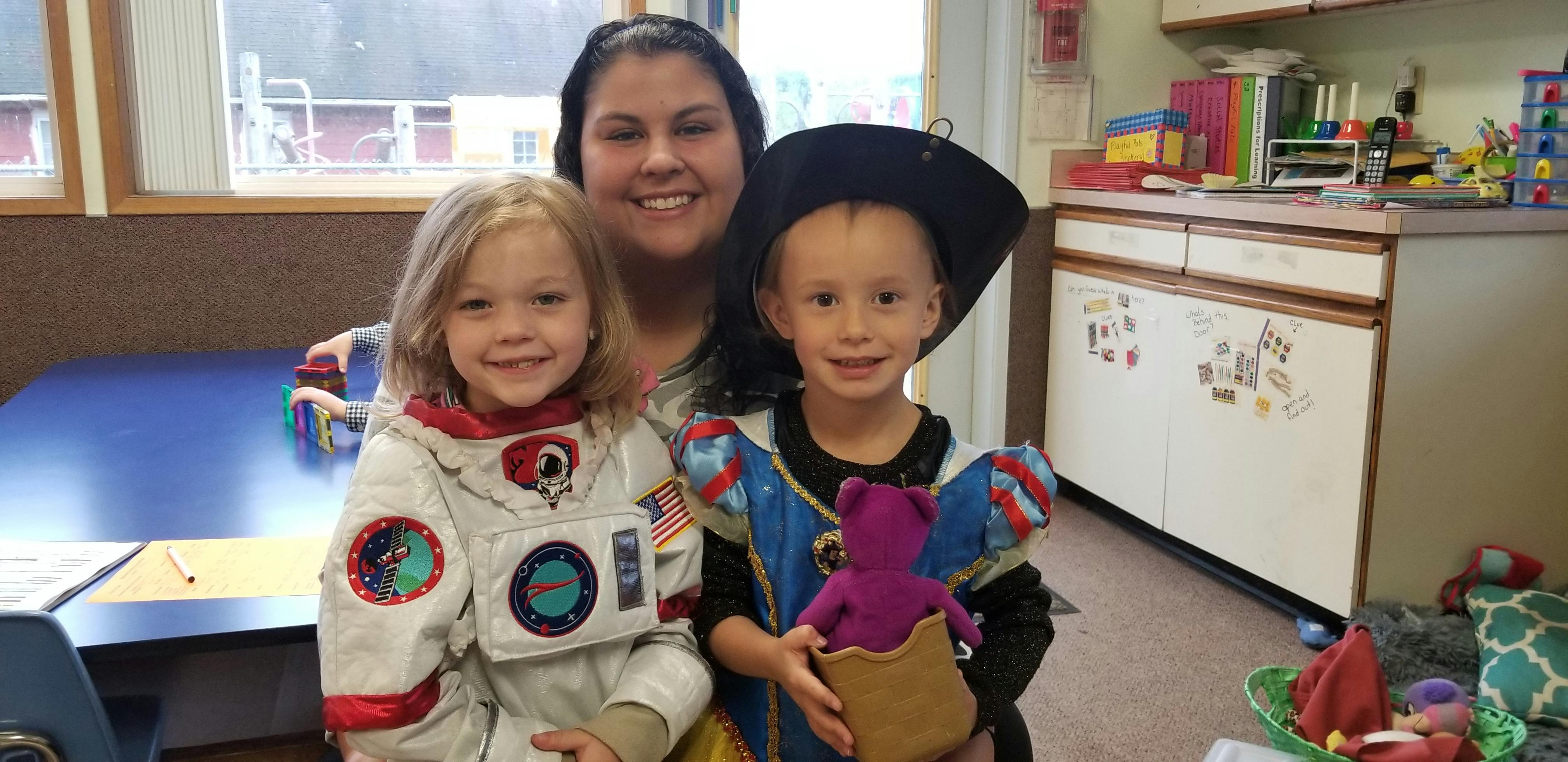 Person with two children in costumes