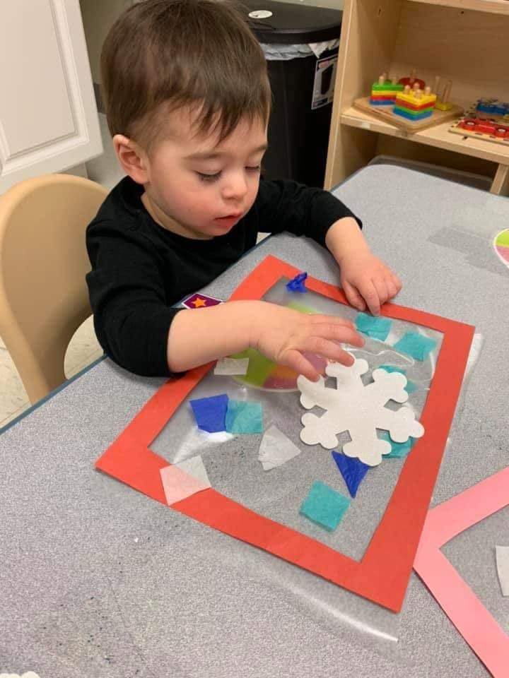Child playing with craft materials on a table