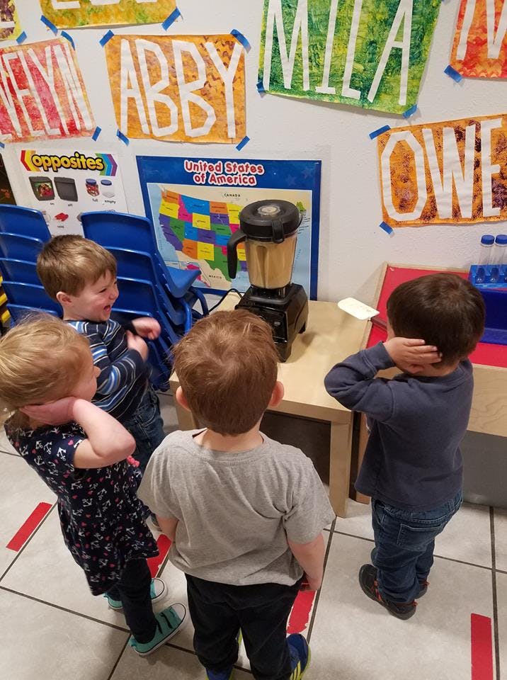Children watching a blender on a table