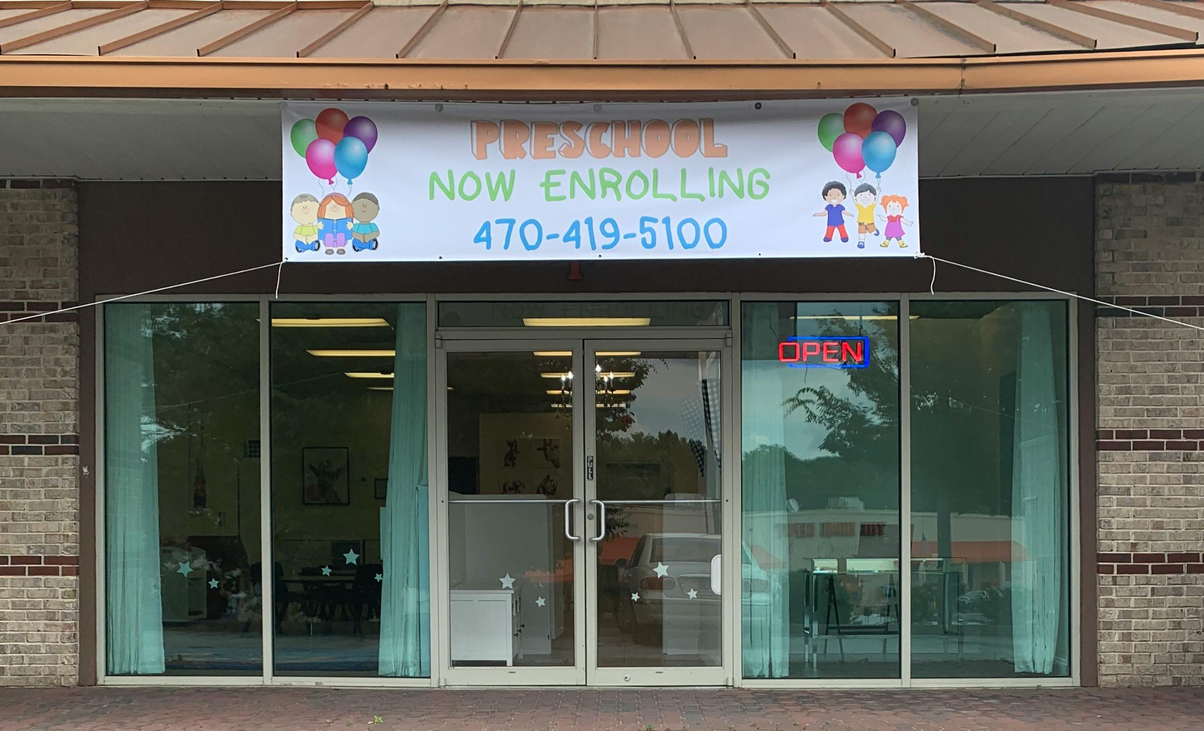 Preschool now enrolling banner above a building entrance