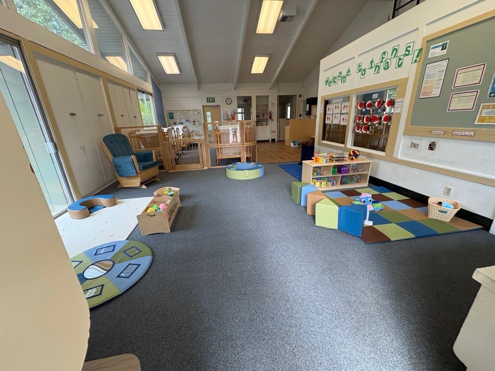indoor play area with cribs and colorful mats