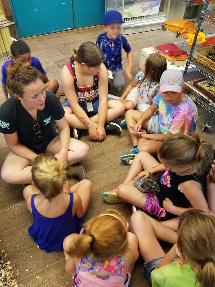 Adult and children sitting on the floor in a circle