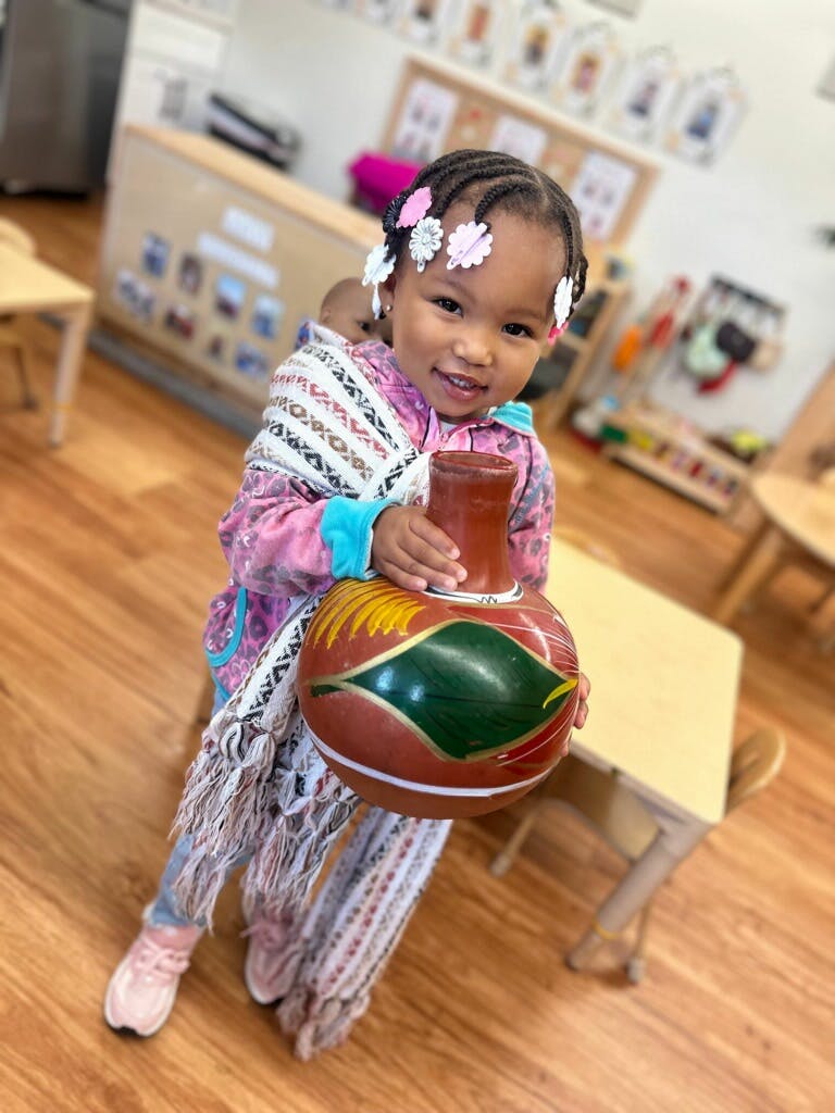 Child holding a decorative pot