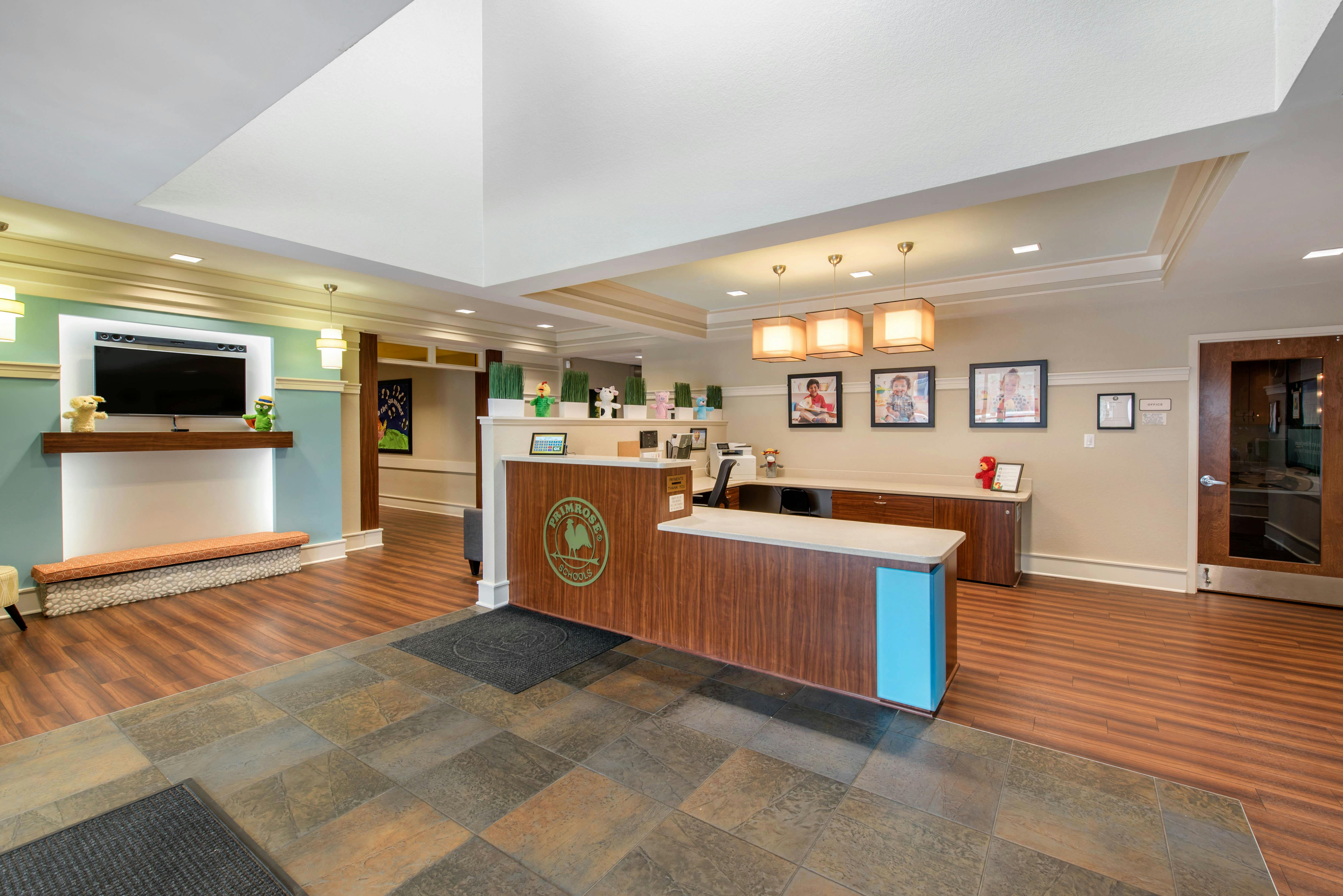 Reception area with a wooden desk and a television display