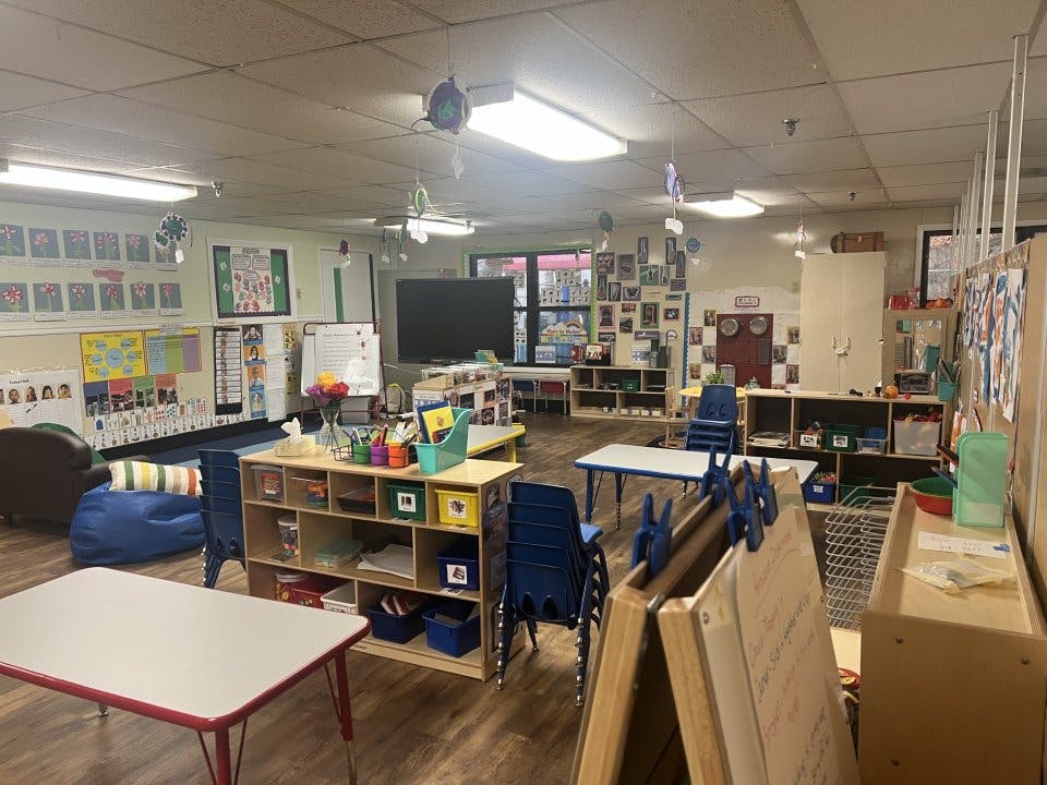 Classroom with several tables, chairs, and learning materials