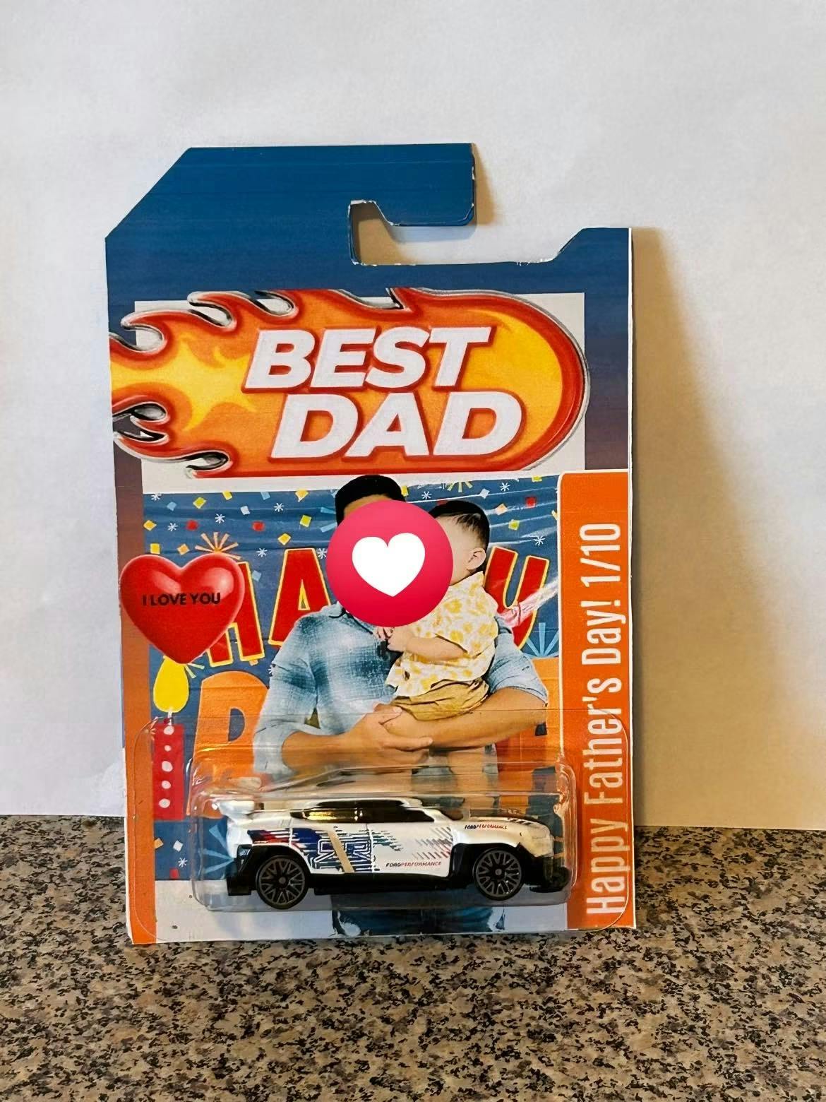 Toy car in custom packaging featuring a photo of an adult holding a child