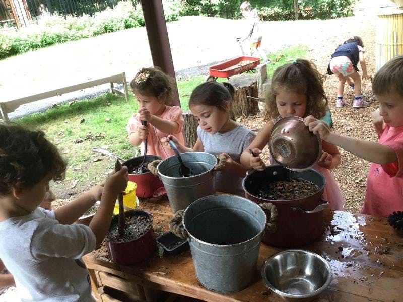 Children playing with buckets and pots outdoors