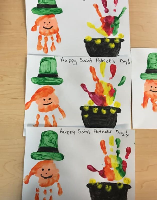 Multiple handprint art projects with leprechauns and pots of gold
