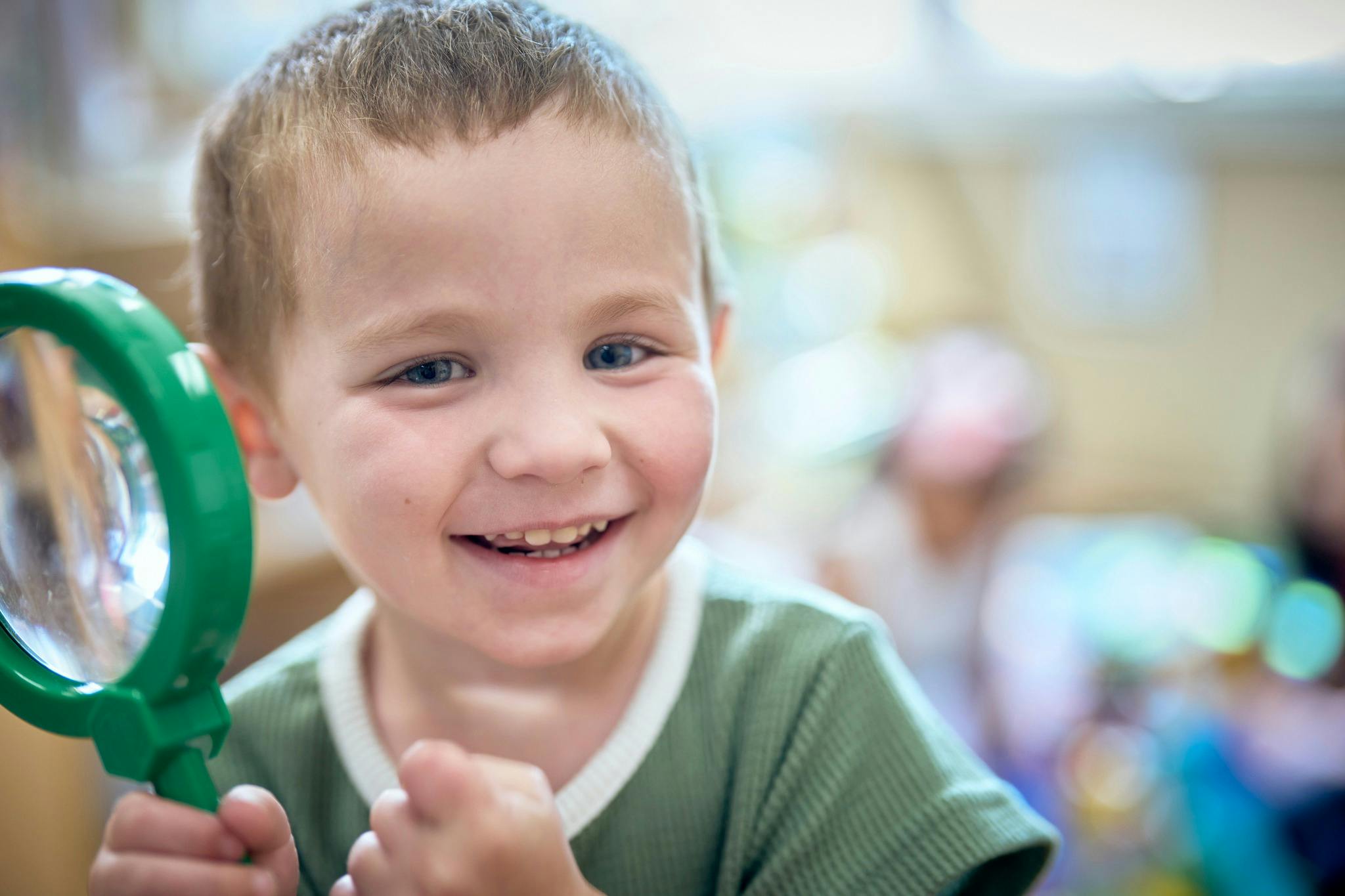 Child holding a magnifying glass