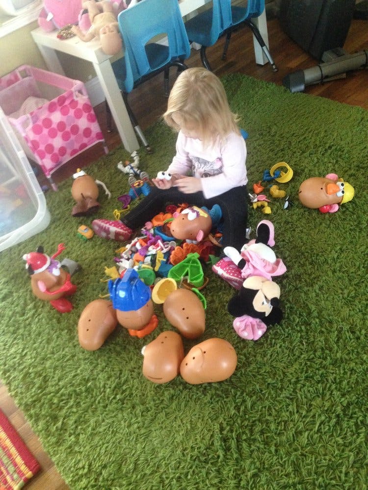 Child playing with toys on a green rug