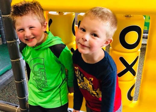 Two children standing in a play area
