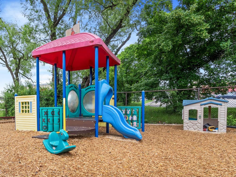 Colorful playground with slide and rocking horse on wood chips