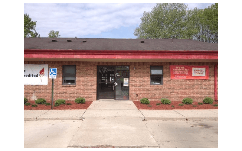 Brick building with a glass double door entrance and two signs on the wall