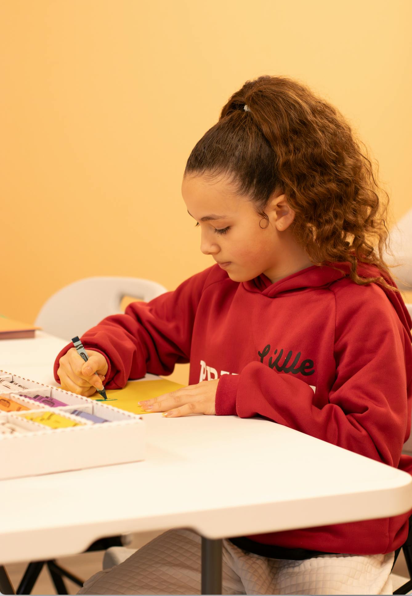 Child drawing on paper at a table